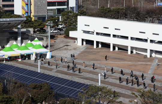 IM선교회에서 운영 중인 국제학교에서 무더기로 확진자가 나오며 코로나19 감염 규모가 다시 증가세에 있는 27일 오전 광주시청 광장에 마련된 코로나19 선별검사소에 시민들이 긴 줄을 서 대기하고 있다.   연합뉴스